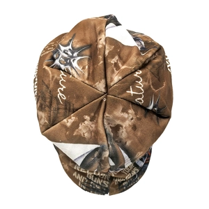Detail showing vintage graffiti print and patchwork stitching on a soft fabric beanie hat