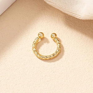 Minimalist gold twisted ear cuff with smooth spherical ends in a sleek geometric design