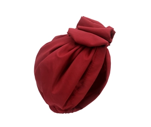 Close-up of deep red turban hat showing fabric texture and elegant pleated details