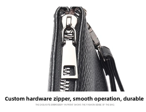 Detail of silver metal zipper slider and lychee grain leather texture on men's clutch bag