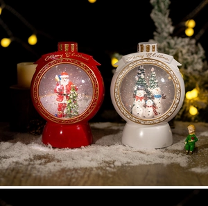 Detail of Santa Claus and Snowman snow globes with Merry Christmas text and warm lights