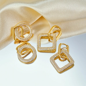 Macro shot of gold-plated geometric earrings featuring micro-pave white cubic zirconia