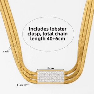 Detailed view of triple-layered golden snake chains with a crystal-encrusted bar pendant