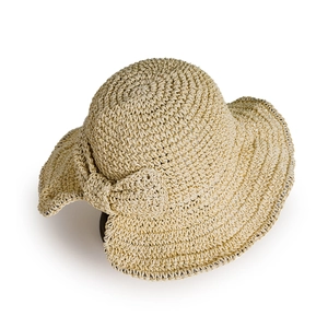 Détail d'un chapeau de paille beige avec un grand ruban élégant pour l'été