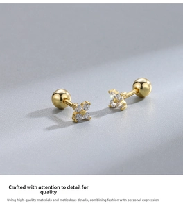 Macro shot of 925 silver gold-plated clover earrings with zircons and ball screw backs