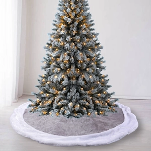 Grey velvet Christmas tree skirt with white faux fur trim under a snowy decorated tree