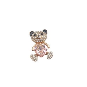 Golden metal teddy bear charm with sparkling rhinestones and a pink heart-shaped crystal