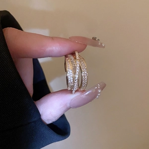 Detailed view of multilayer gold ring with baguette and round cut pavé crystals