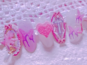 Detail of Y2K style press-on nails with 3D angel, purple butterfly, and heart charms