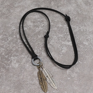 Close-up of adjustable black leather cord necklace with bronze and silver feather pendants