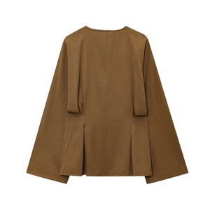 Detail view of the back pleat design on a brown loose-fit long sleeve shirt
