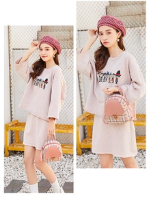 Mini zaino in tela a scacchi rosa e pelle abbinato a un outfit sportivo casual