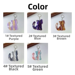 Macro shot showing five colorful marble texture acrylic cat keychains with silver rings