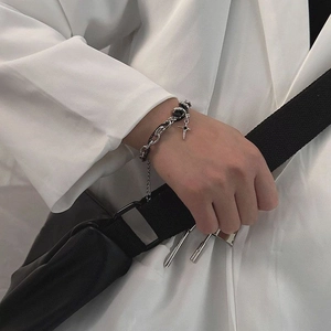 Minimalist titanium steel bracelet with black diamond star pendant on a white suit cuff