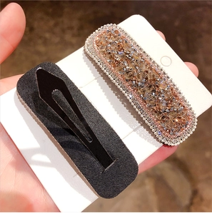 Macro view of rectangular champagne rhinestone BB hair clips with rose gold metal base