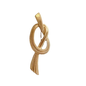 Elegant gold vintage rope knot brooch with detailed metallic texture and retro court style