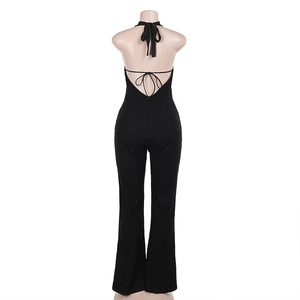 Detail of black halter jumpsuit showing backless criss-cross lacing and textured fabric