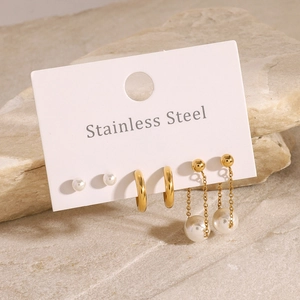 Three-pair gold stainless steel earring set with pearls and hoops on natural stone