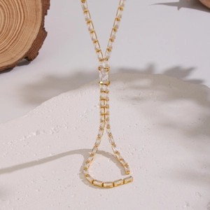 Elegant gold bamboo-style necklace with square zircon tassels on white stone