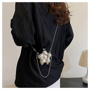 Détail du mini sac argenté en forme de fleur avec perle et élégante bandoulière chaîne