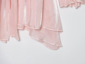 Vue macro détaillée du tissu rose scintillant avec un design de volants irréguliers