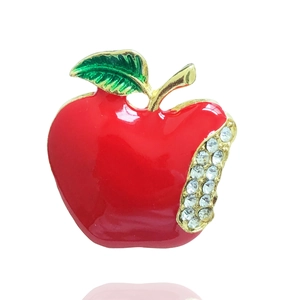 Detail of red enamel apple brooch with green leaves and sparkling rhinestone accents