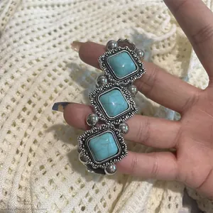 Gros plan d'un bracelet extensible bohème avec pierres bleues et cadres à fleurs argentés
