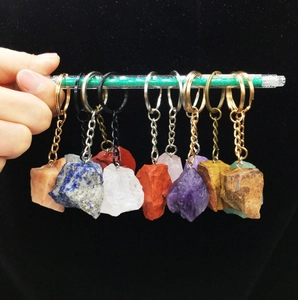 Macro detail of assorted raw crystal stone keychains on colorful metal rings