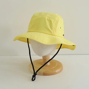 Detailed view of yellow quick-dry sun hat with wide brim and adjustable chin strap