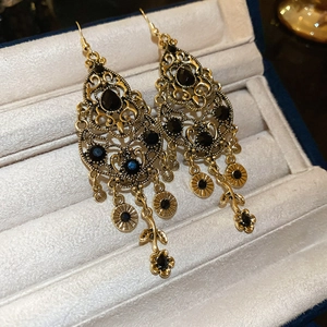 Close-up of vintage flower earrings with black gemstones in a jewelry box