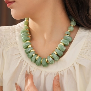 Détail du collier vintage avec perles vertes effet marbre et accents dorés brillants