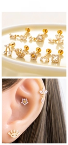 Detail of gold titanium labret studs with zircon in flower, heart, and eye shapes