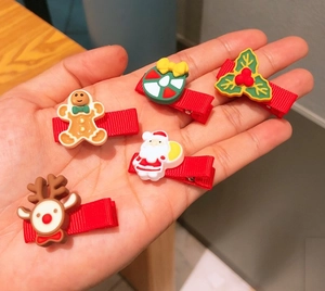 Close-up of five Christmas hair clips featuring gingerbread man and Santa Claus 3D resin motifs