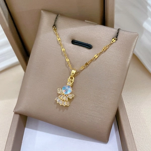 Close-up of golden angel necklace with opal and zircon in a jewelry gift box