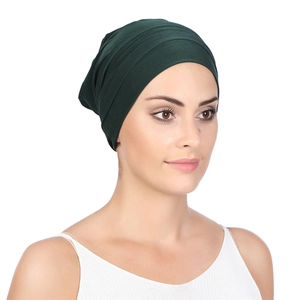 Detail of dark green pleated headwrap turban hat with soft knitted fabric texture