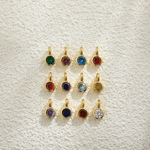 Macro view of twelve colorful round birthstone pendants with 18K gold plated bezel settings