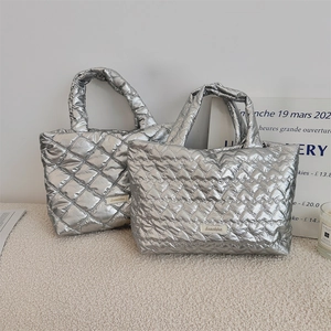 Detail of silver quilted tote bags with heart patterns and metallic finish texture