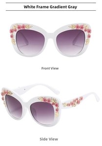 Detailed view of white baroque sunglasses with 3D pink flowers and gold leaf accents