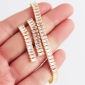 Detailed close-up of a gold-plated bracelet featuring rectangular-cut zircon stones