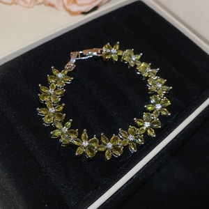 Detailed close-up of olive green marquise zircon flower bracelet on black velvet base