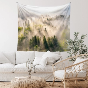 Detail of bohemian forest tapestry with sun rays hanging over a white sofa