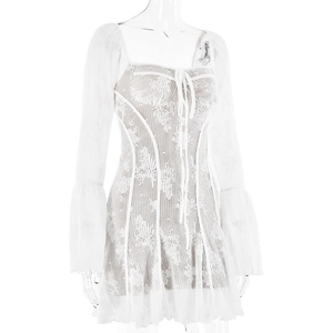 Détail d'une mini robe en dentelle blanche avec manches évasées et tissu transparent