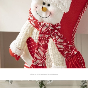 Close-up of a festive red knitted Christmas stocking with a 3D snowman and holiday greetings