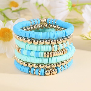 Close-up of bohemian blue and mint green clay heishi bead bracelet set with gold accents