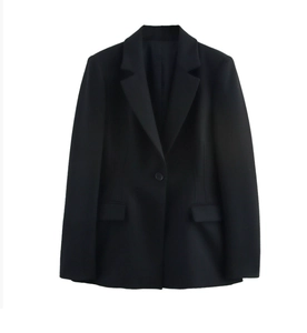Dettaglio di un blazer nero sfiancato con revers a dente e chiusura a un bottone
