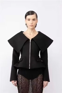Detail of elegant black waist-cinching jacket with large lapels and ruffled hem accents