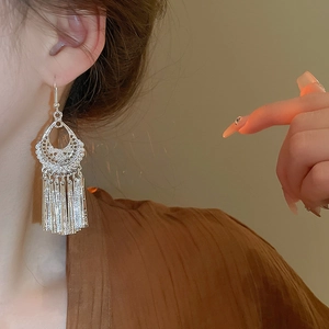 Vintage silver hollow-out bell fringe drop earrings worn by a model in close-up shot