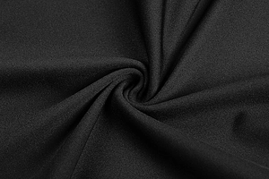 Macro shot of premium black knitted fabric with textured pleats and silky finish