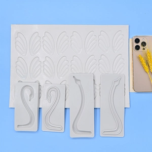 White silicone swan neck and wing fondant molds for cake decorating on blue background
