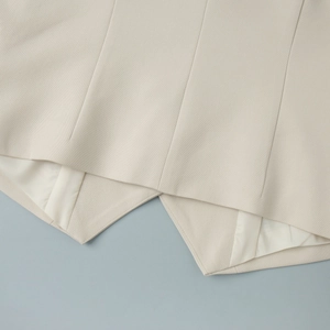 Close-up of beige vest hem showing fine twill texture and smooth inner lining